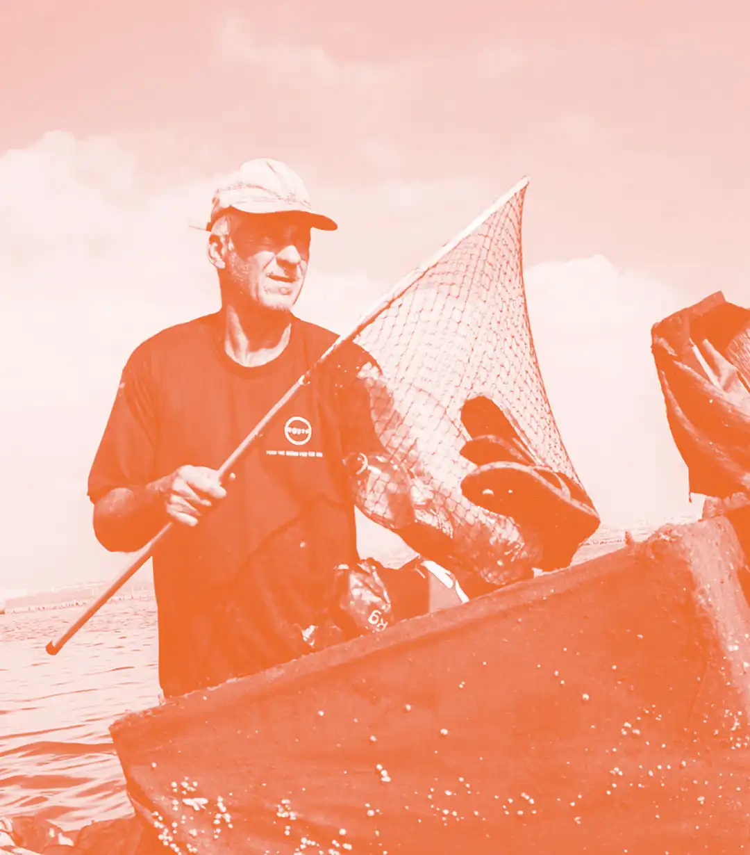 Immagine tono su tono di un volontario che ripulisce il mare.